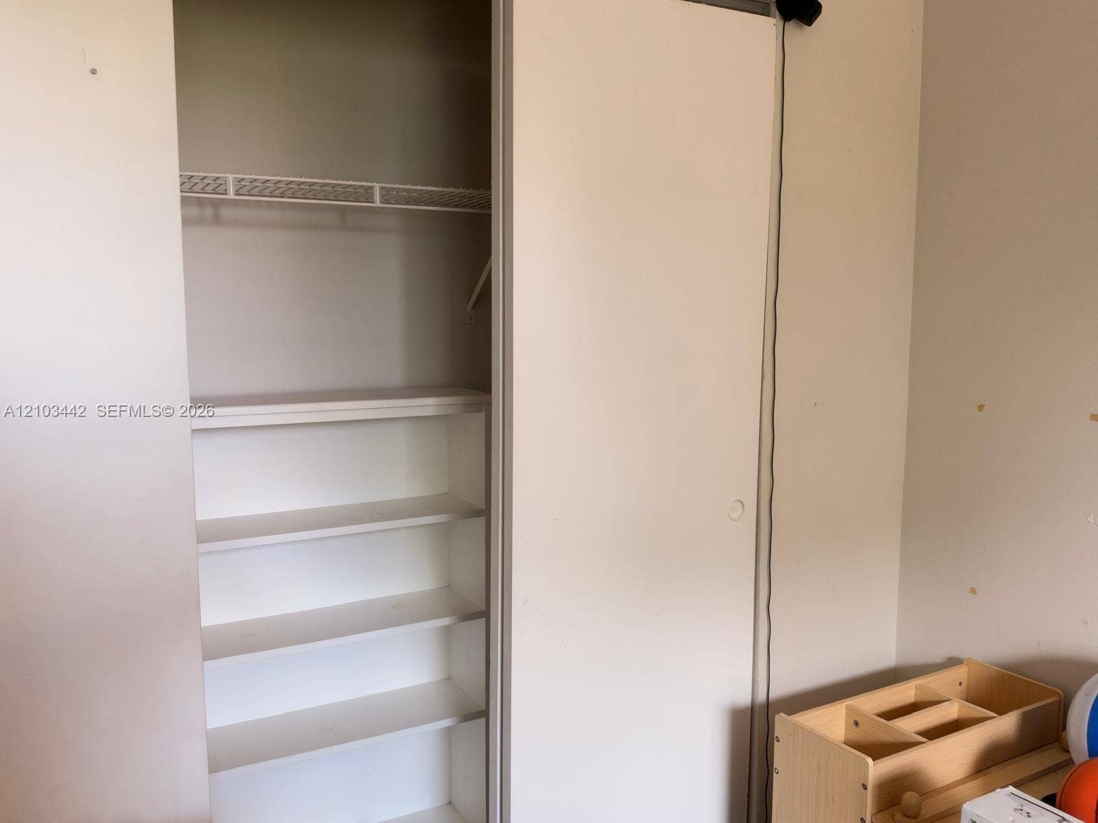 8721 Wiles Road, #303, Coral Springs, FL 33067 Closet featuring a sliding door, white interior shelving, and a wire rack