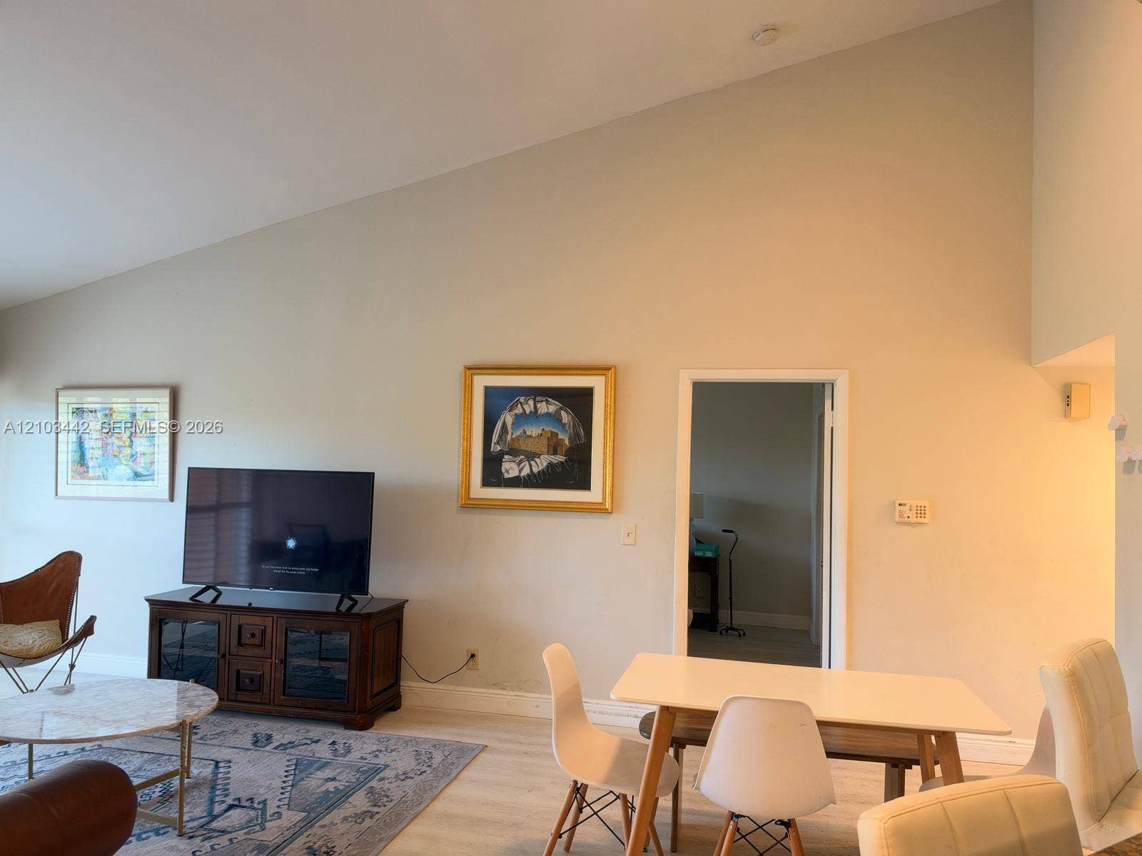 8721 Wiles Road, #303, Coral Springs, FL 33067 Vaulted ceiling featuring a neutral wall finish and wood-finish flooring