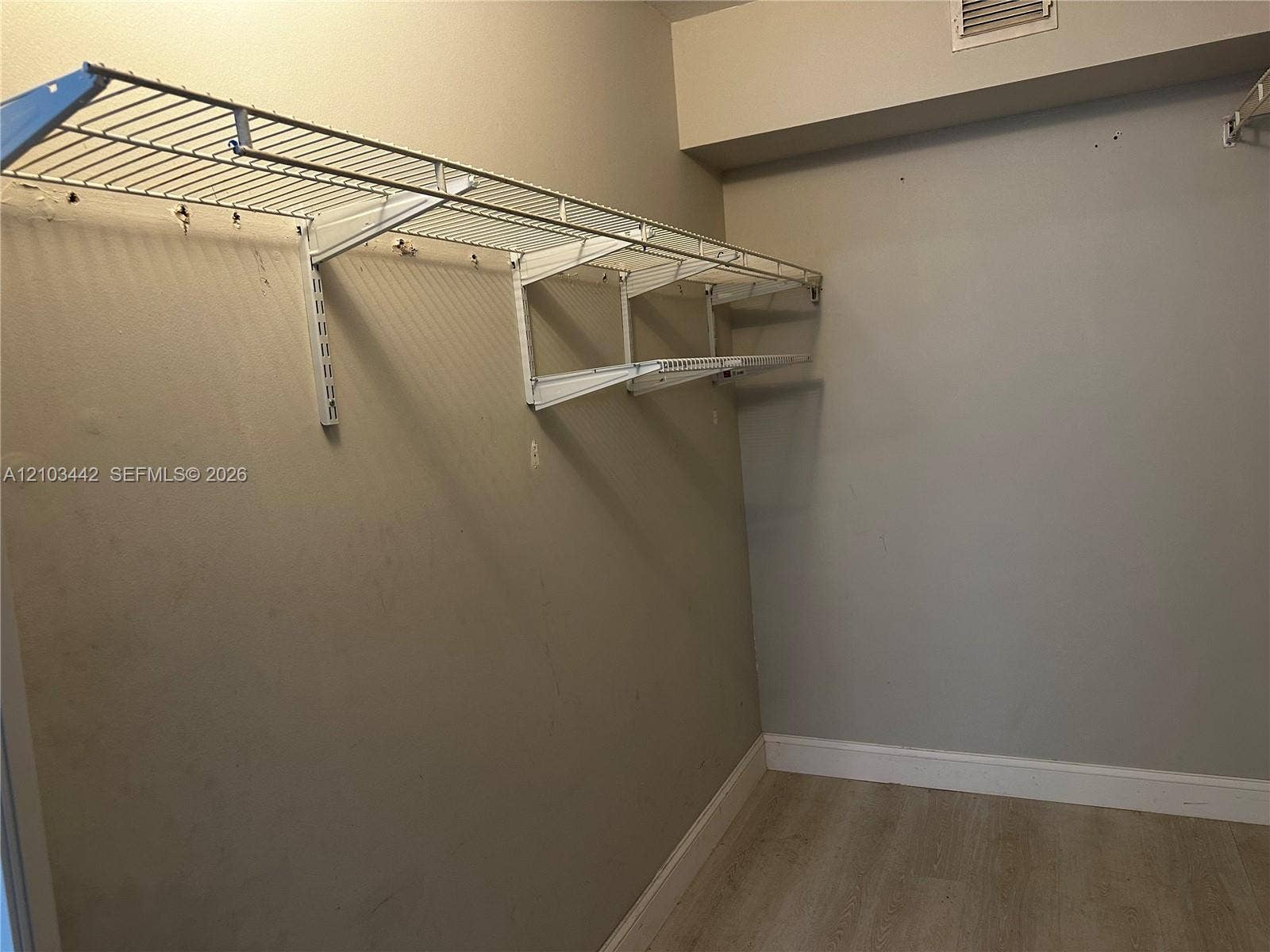 8721 Wiles Road, #303, Coral Springs, FL 33067 Storage space featuring neutral wall paint, wood-finish flooring, and white wire shelving