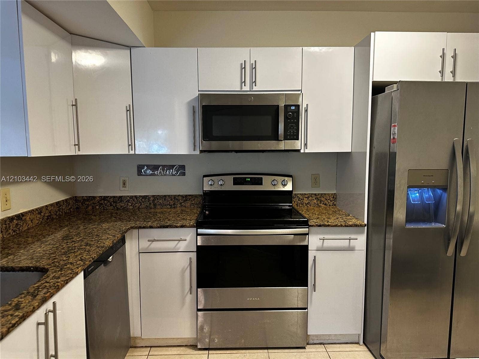 8721 Wiles Road, #303, Coral Springs, FL 33067 Kitchen featuring white high-gloss cabinetry, stone-finish countertops, stainless steel appliances, and tile flooring