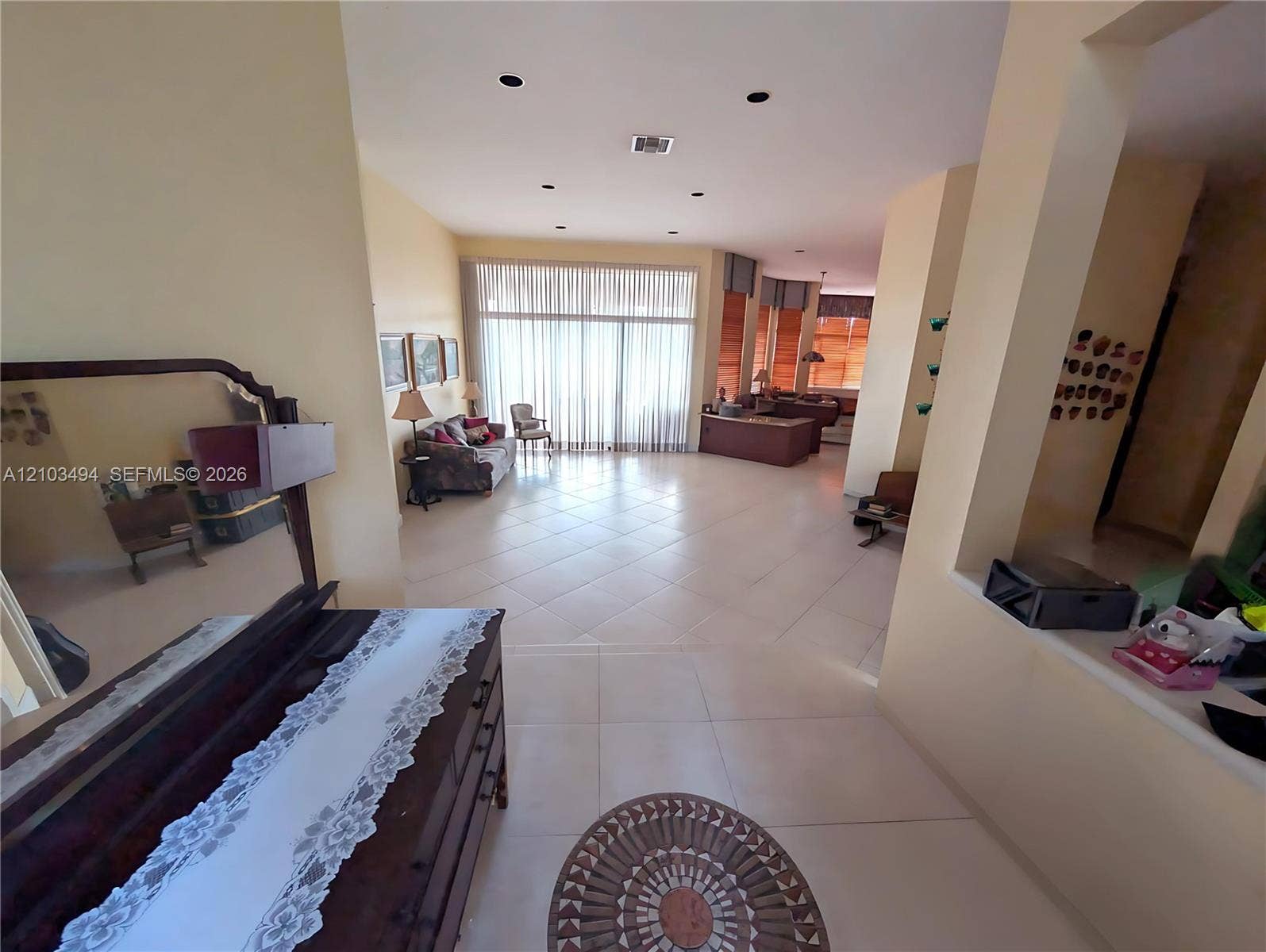 Open-concept interior featuring large-format diagonal tile flooring, recessed lighting, and floor-to-ceiling windows