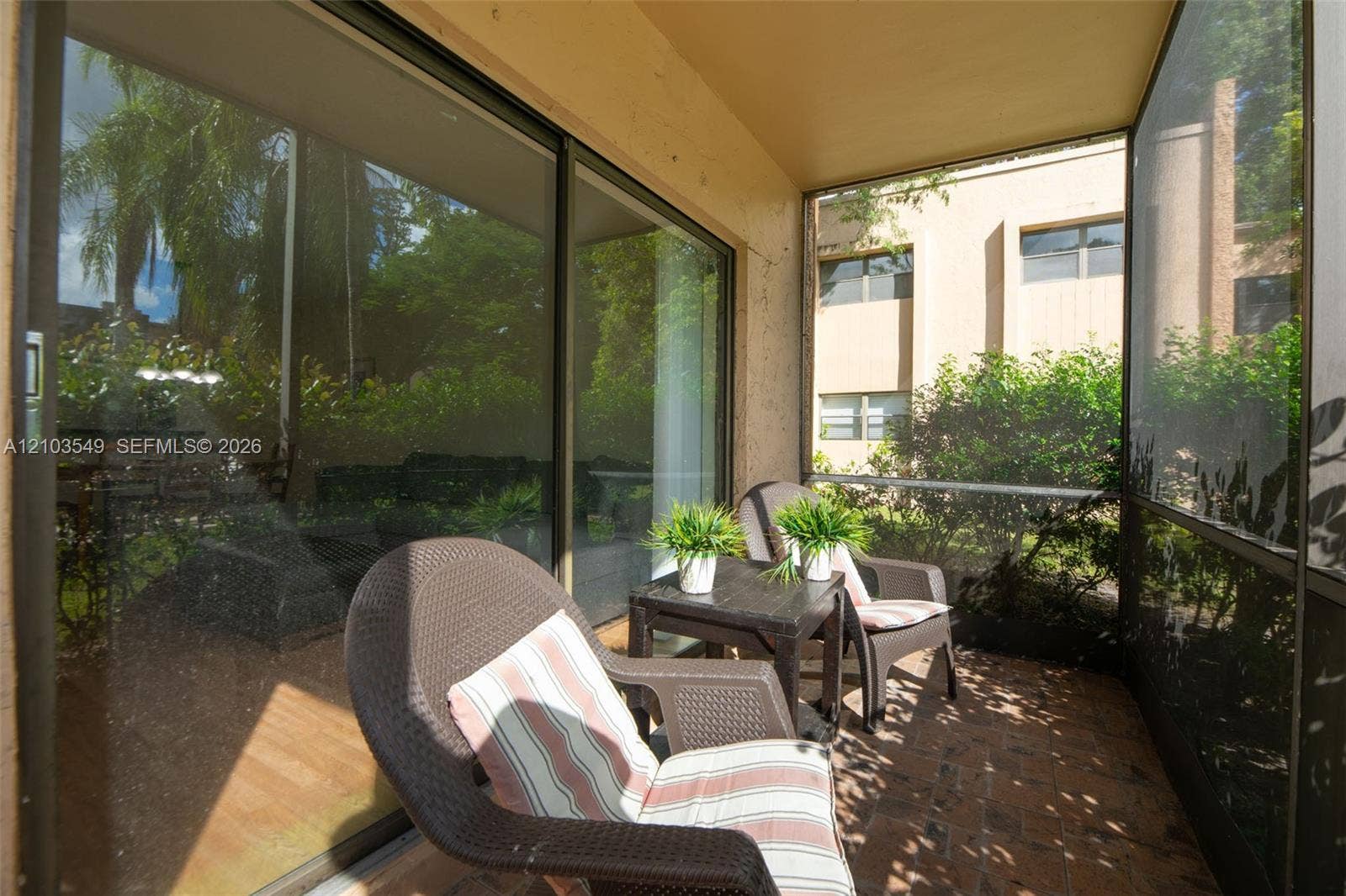 8901 N New River Canal Road, #4W, Plantation, Plantation, FL 33324 Screened-in porch featuring brick paver flooring, sliding glass doors, and structured metal framing