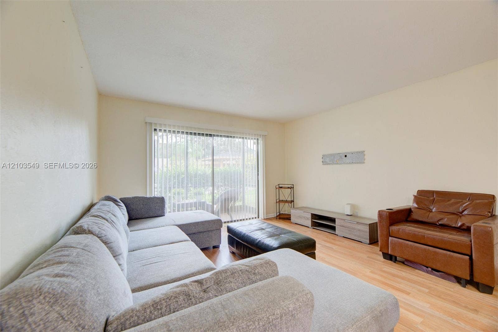 8901 N New River Canal Road, #4W, Plantation, Plantation, FL 33324 Interior living space featuring wood-finish flooring, neutral wall tones, and glass sliding doors with vertical blinds