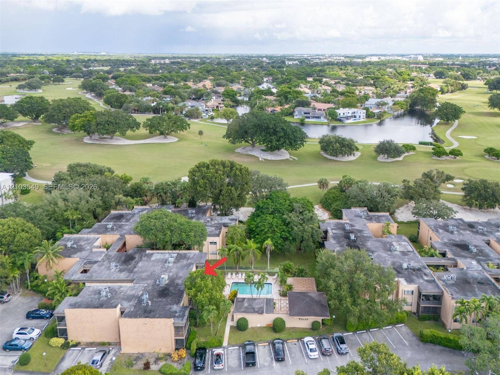8901 N New River Canal Road, #4W, Plantation, Plantation, FL 33324 Aerial perspective of multi-family property featuring an outdoor swimming pool, paved parking area, and proximity to golf course grounds and water features