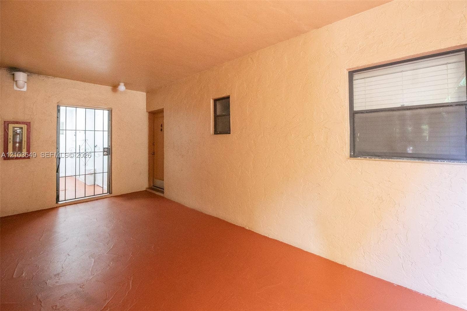 8901 N New River Canal Road, #4W, Plantation, Plantation, FL 33324 Covered patio featuring textured wall finishes, solid flooring, a horizontal sliding window, and a metal security screen door