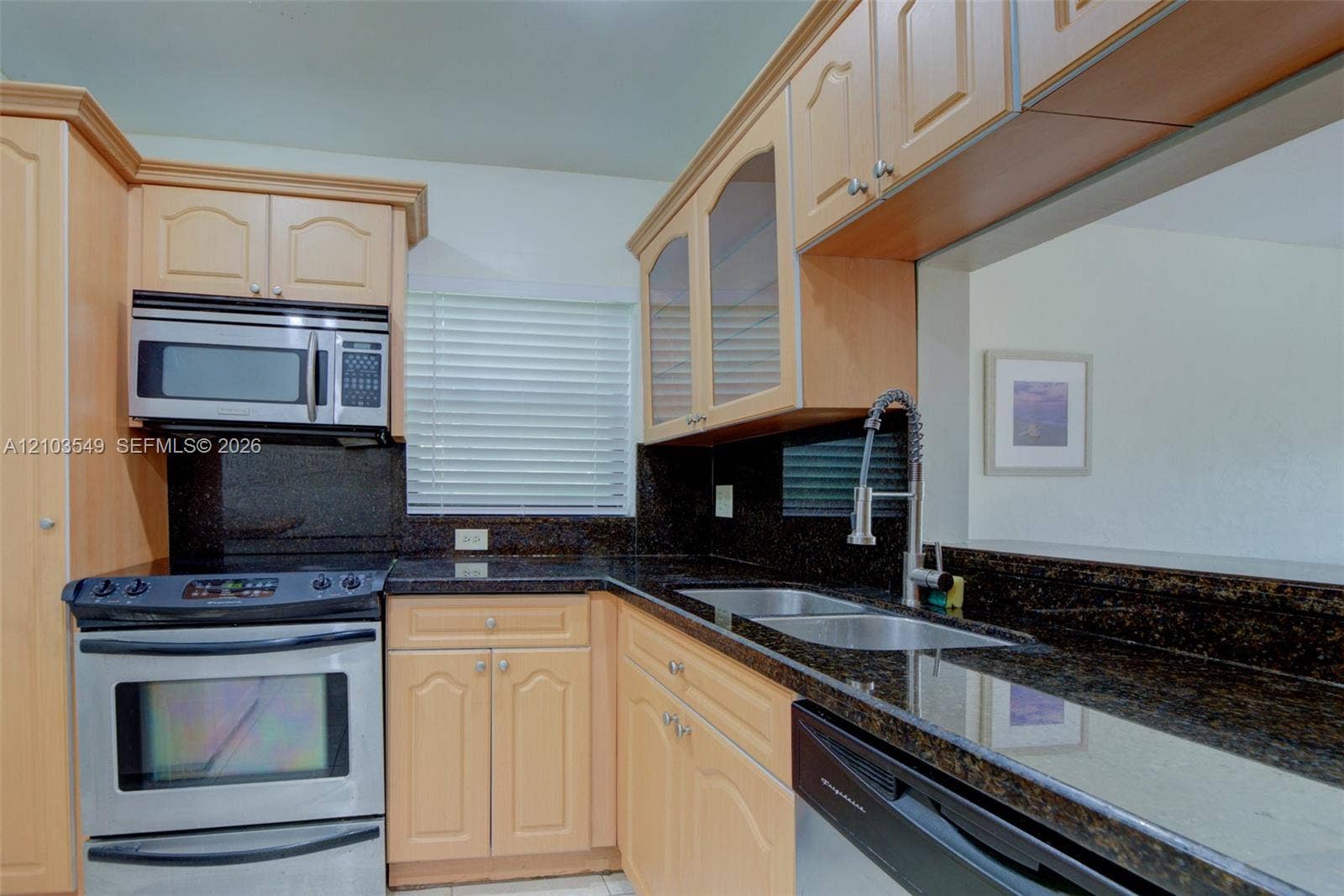 8901 N New River Canal Road, #4W, Plantation, Plantation, FL 33324 Kitchen featuring light-tone cabinetry, dark stone countertops, stainless steel appliances, dual-basin stainless steel sink with high-arc pull-down faucet, and glass-panel upper cabinet doors