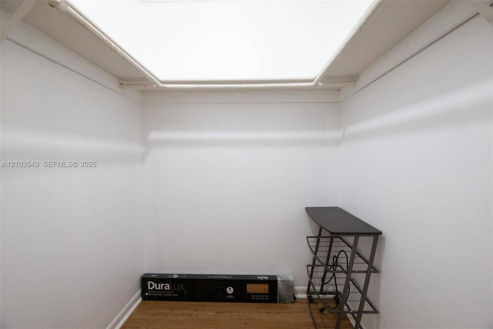 8901 N New River Canal Road, #4W, Plantation, Plantation, FL 33324 Reach-in storage closet featuring wood-finish flooring, white walls, overhead lighting, and white built-in shelving rods