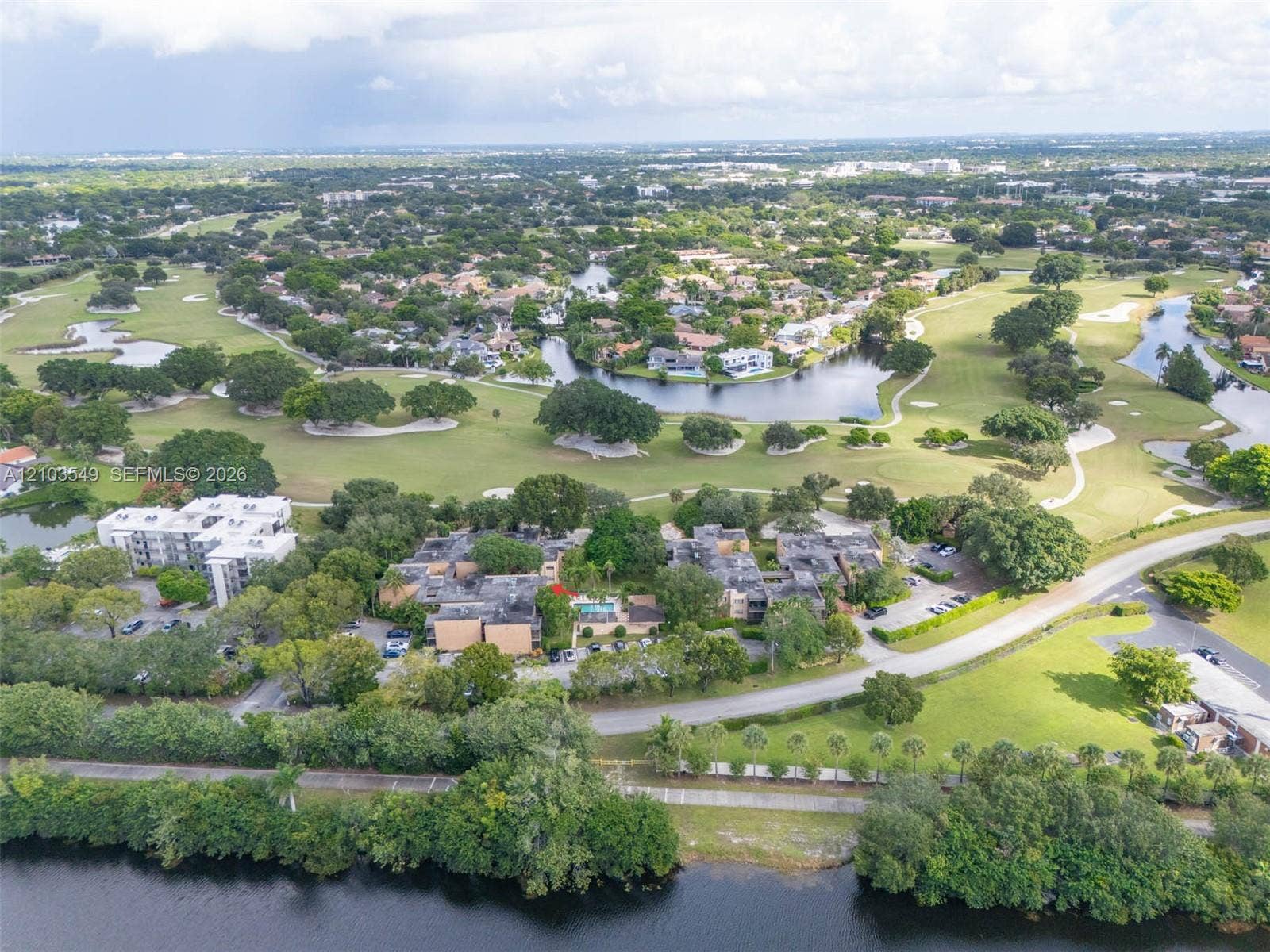 8901 N New River Canal Road, #4W, Plantation, Plantation, FL 33324 Aerial perspective featuring multi-story residential buildings, paved surface parking, mature landscaping, and surrounding golf course grounds with water features