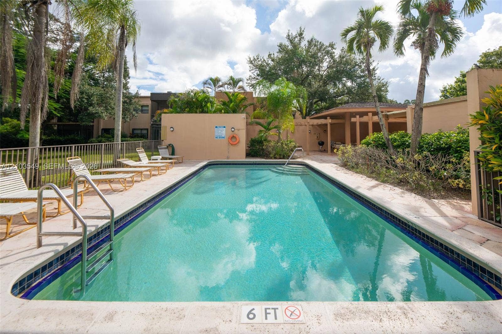 8901 N New River Canal Road, #4W, Plantation, Plantation, FL 33324 In-ground swimming pool featuring a tiled waterline, stone-finish pool deck, metal handrail, and covered pergola