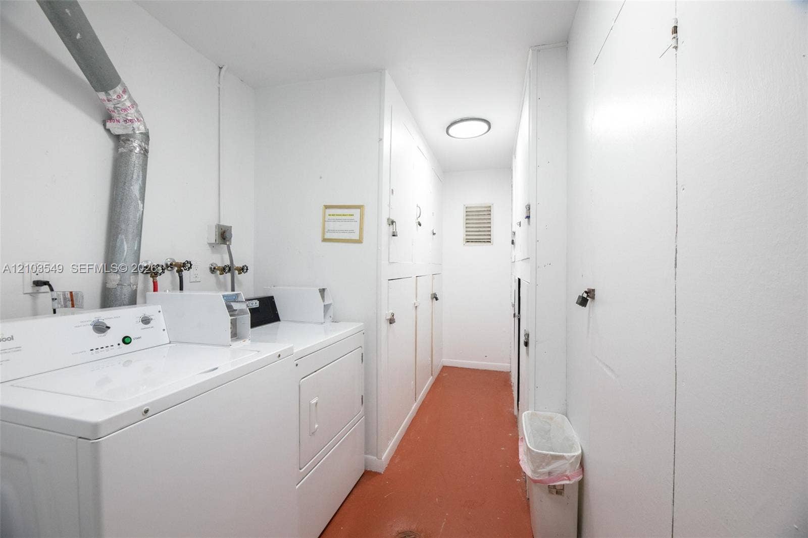 8901 N New River Canal Road, #4W, Plantation, Plantation, FL 33324 Utility space featuring extensive floor-to-ceiling cabinetry, laundry machines, and solid-finish flooring