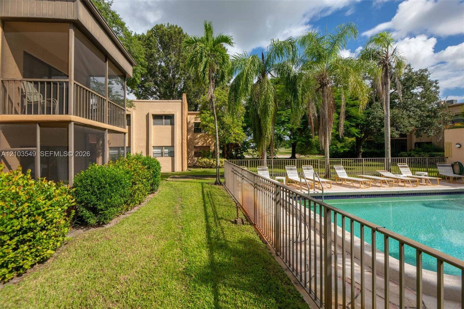 8901 N New River Canal Road, #4W, Plantation, Plantation, FL 33324 Multi-level screened lanais featuring exterior railings, swimming pool enclosed by metal fencing, and manicured landscaping with mature palm trees