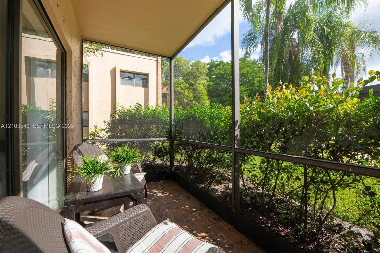 8901 N New River Canal Road, #4W, Plantation, Plantation, FL 33324 Screened-in lanai featuring brick pavers and exterior access to surrounding mature landscaping