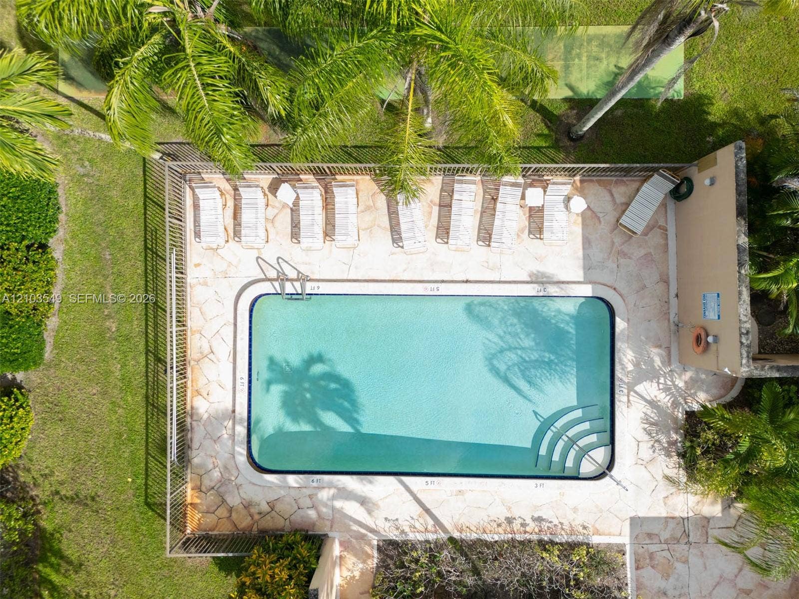 8901 N New River Canal Road, #4W, Plantation, Plantation, FL 33324 In-ground pool featuring built-in stairs, perimeter fencing, flagstone patio, and mature palm trees
