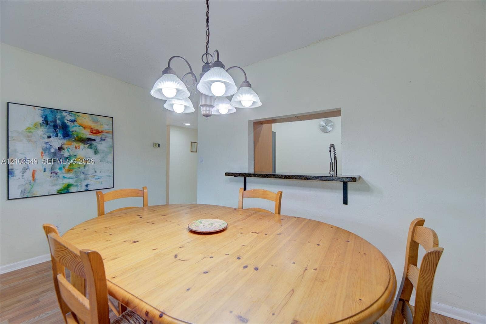 8901 N New River Canal Road, #4W, Plantation, Plantation, FL 33324 Dining space featuring a multi-bulb chandelier and a wall pass-through with a stone-finish ledge