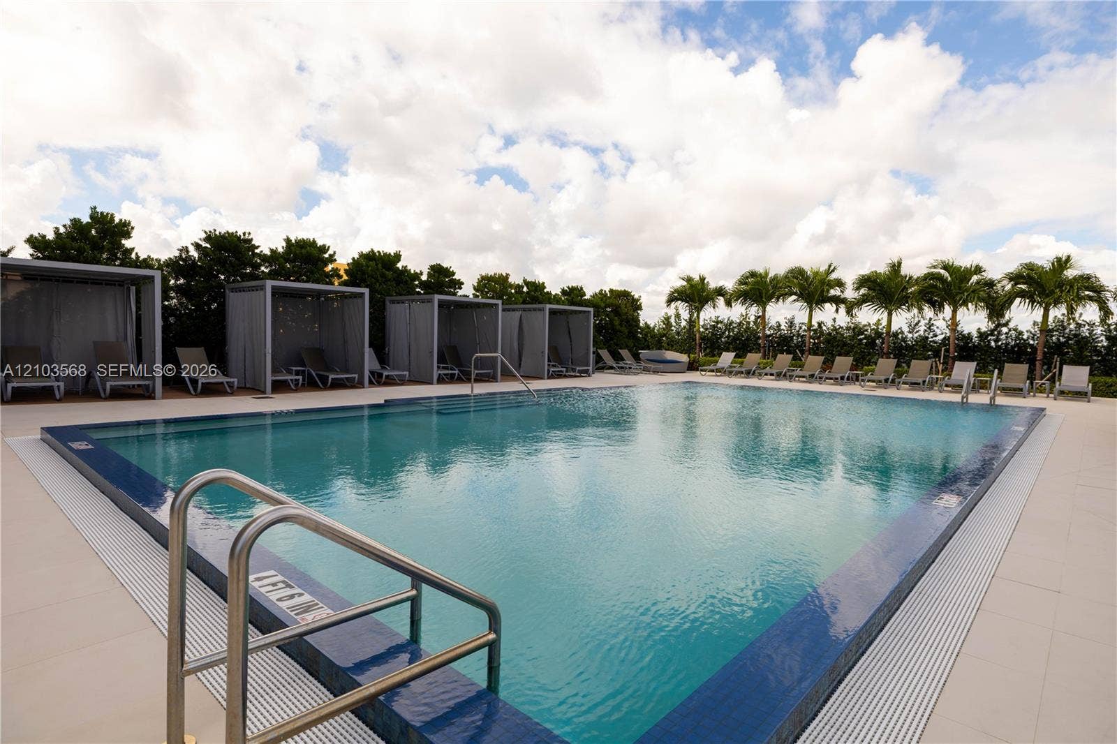 7901 Hispanola Avenue, #801, North Bay Village, FL 33141 Swimming pool with integrated metal handrails, expansive tile surround, and multiple permanent poolside cabanas