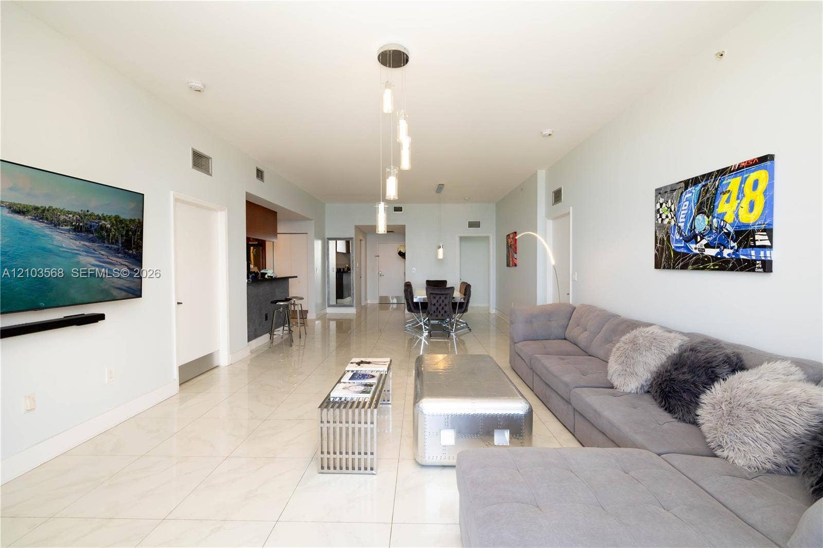 7901 Hispanola Avenue, #801, North Bay Village, FL 33141 Open-concept interior featuring large-format tile flooring, recessed ceiling lighting, and a multi-pendant light fixture