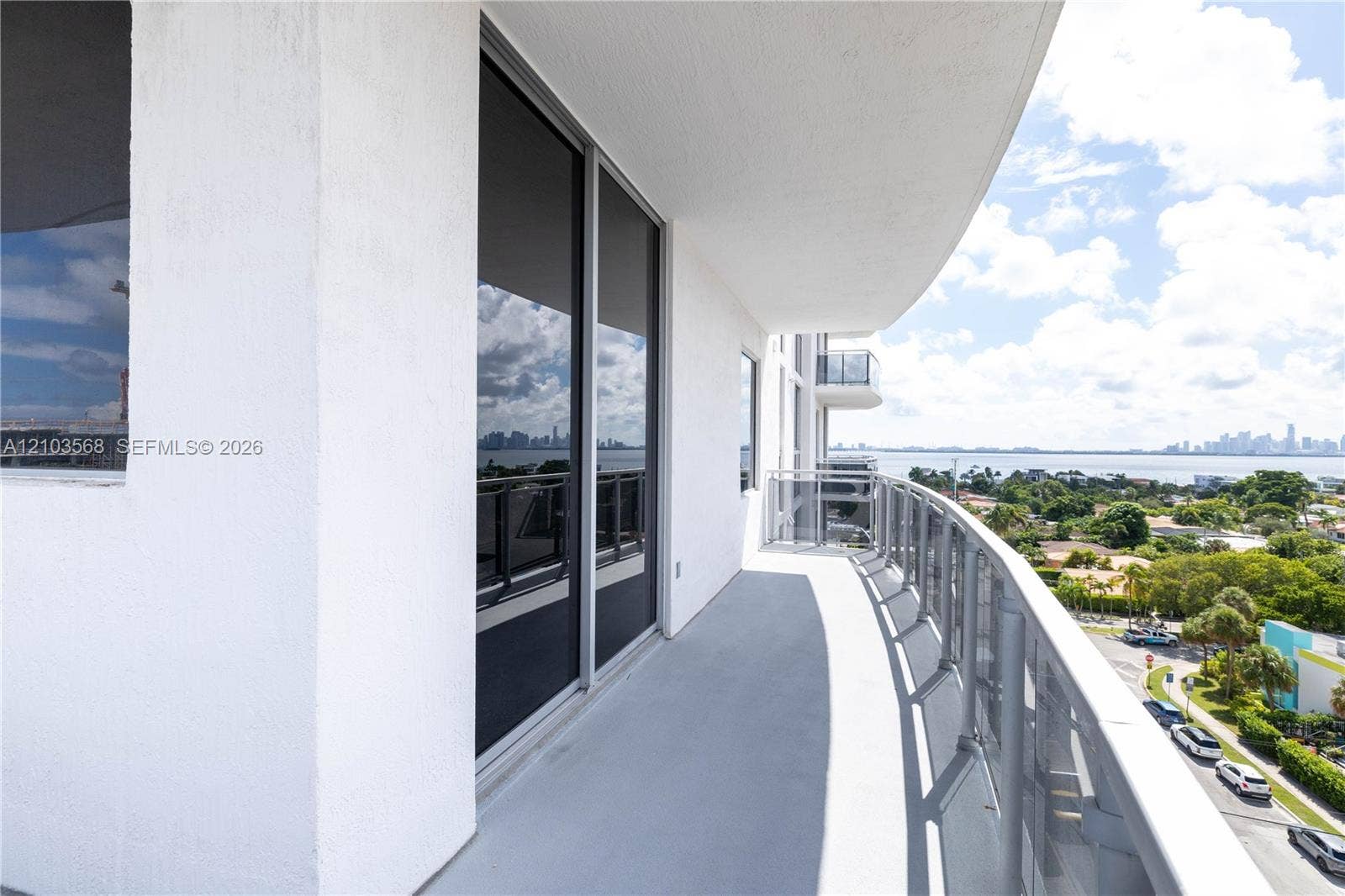 7901 Hispanola Avenue, #801, North Bay Village, FL 33141 Curved balcony featuring a metal railing, concrete flooring, and full-height sliding glass doors