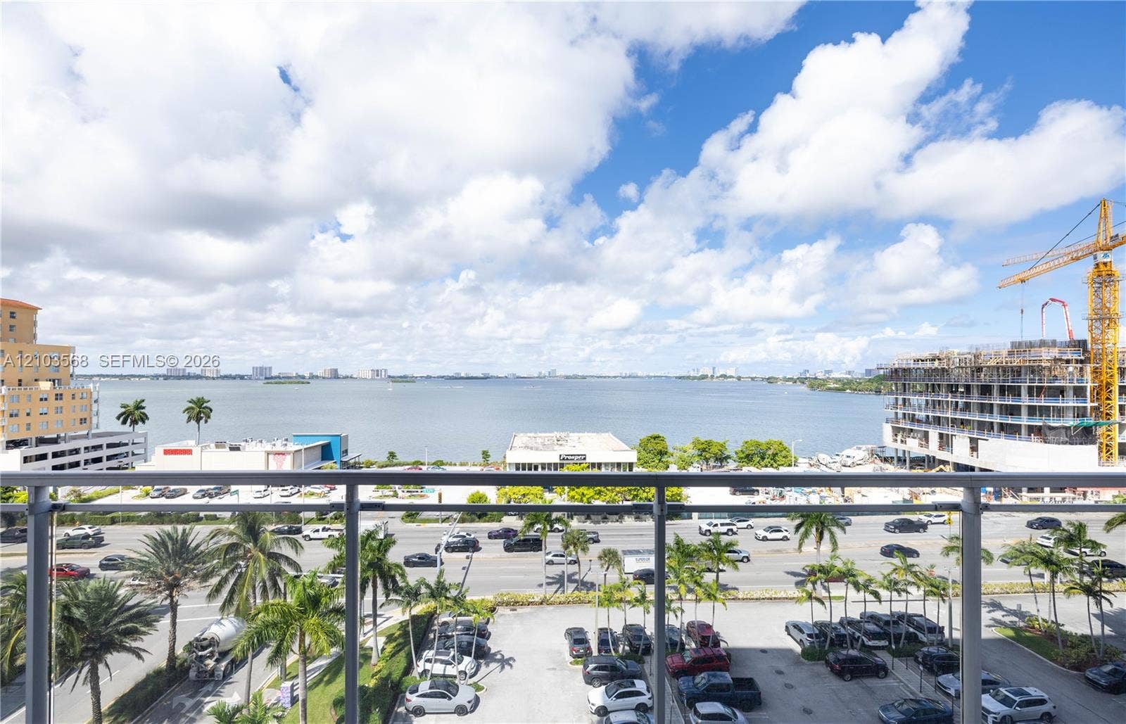 7901 Hispanola Avenue, #801, North Bay Village, FL 33141 Elevated balcony featuring a glass and metal railing overlooking expansive water scenery and coastal landscape