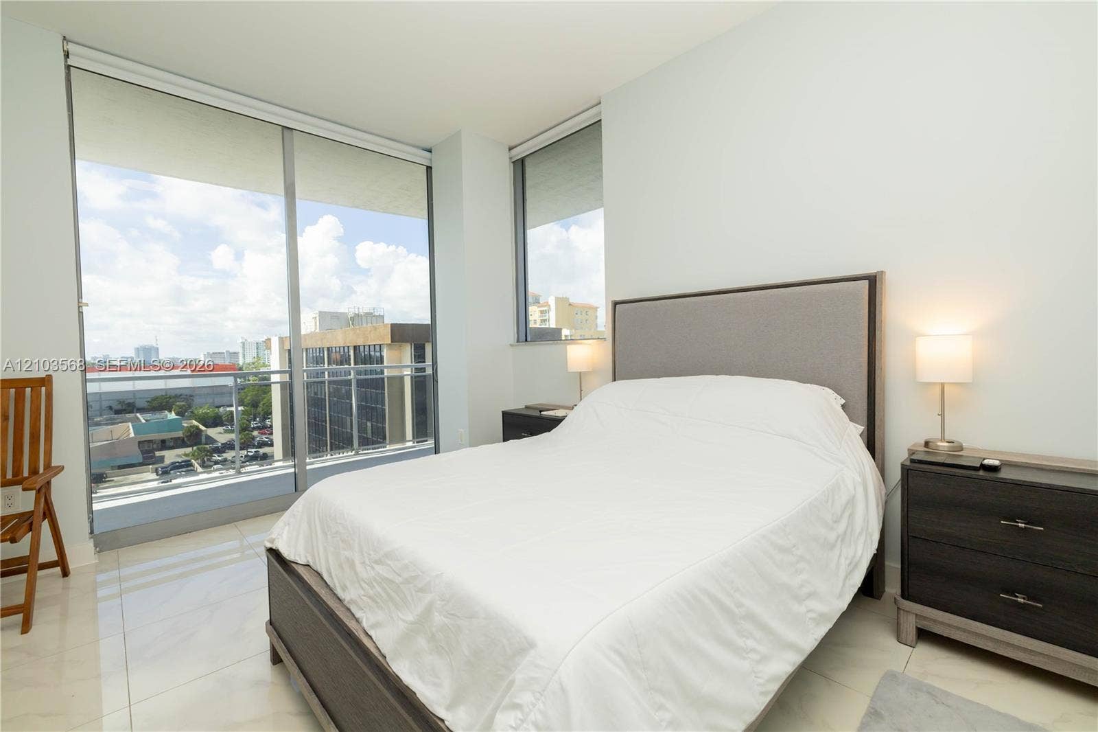 7901 Hispanola Avenue, #801, North Bay Village, FL 33141 Floor-to-ceiling windows, private balcony with metal railing, and light-toned tile flooring
