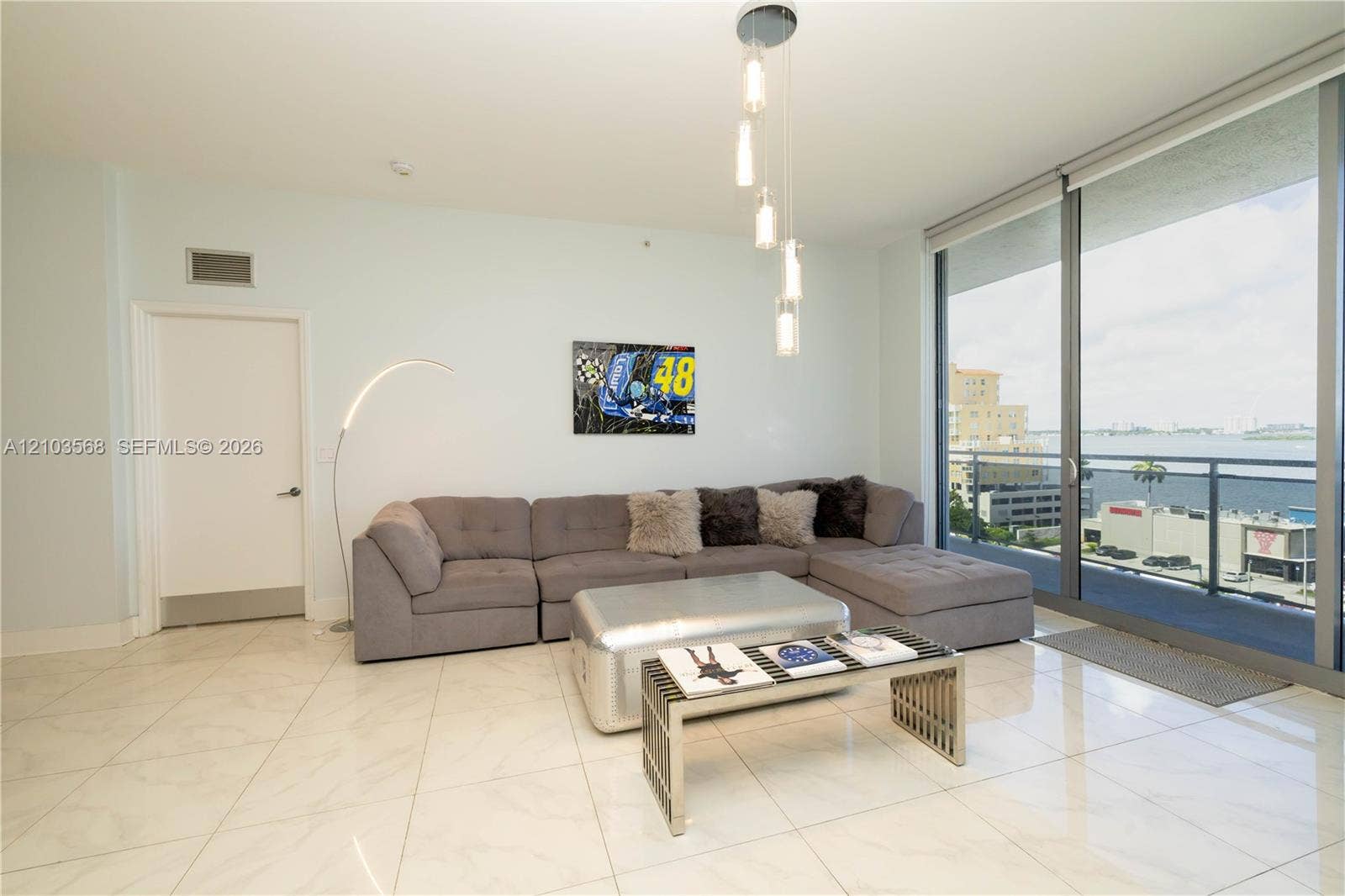 7901 Hispanola Avenue, #801, North Bay Village, FL 33141 Large-format tile flooring, floor-to-ceiling glass panel windows, and a multi-pendant light fixture