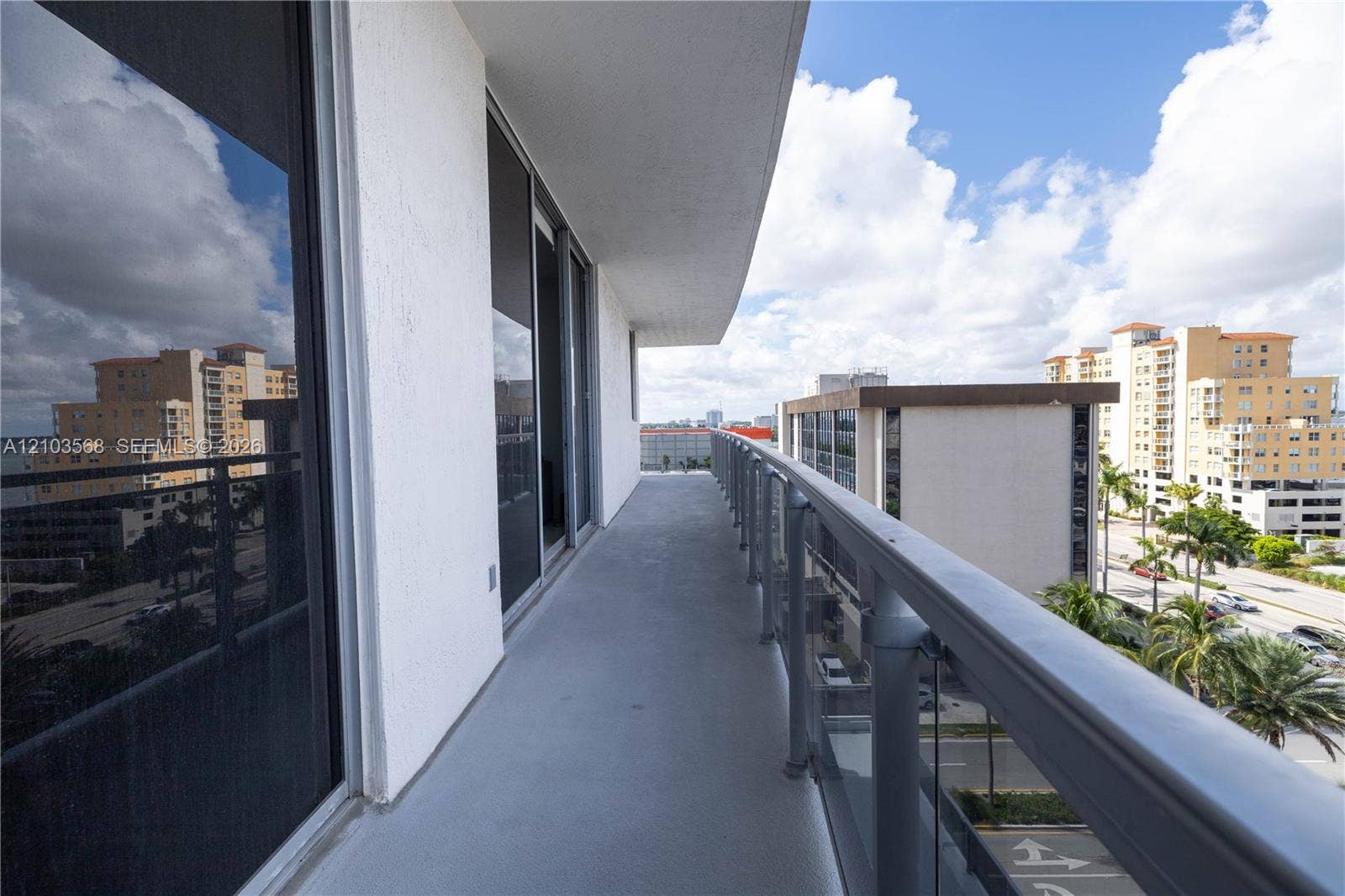 7901 Hispanola Avenue, #801, North Bay Village, FL 33141 Covered balcony featuring concrete flooring, full-length glass sliding doors, and a metal railing with glass panels