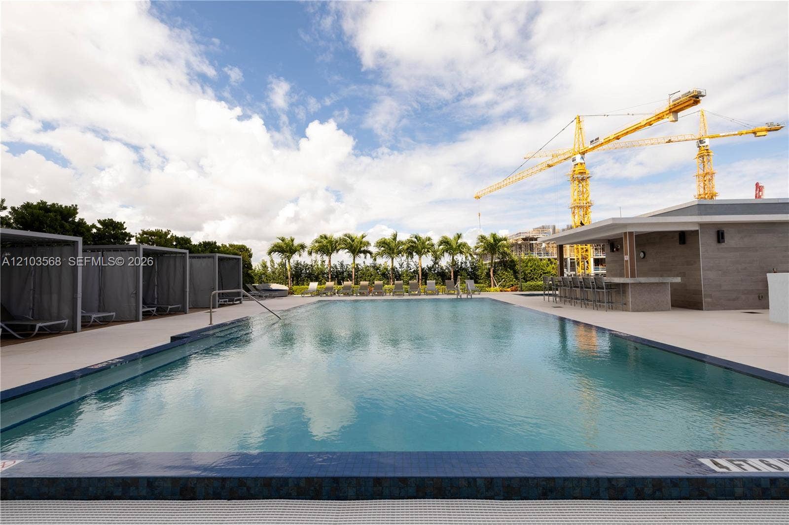 7901 Hispanola Avenue, #801, North Bay Village, FL 33141 Swimming pool with tile edging, paved deck, multiple cabanas, and integrated outdoor bar area
