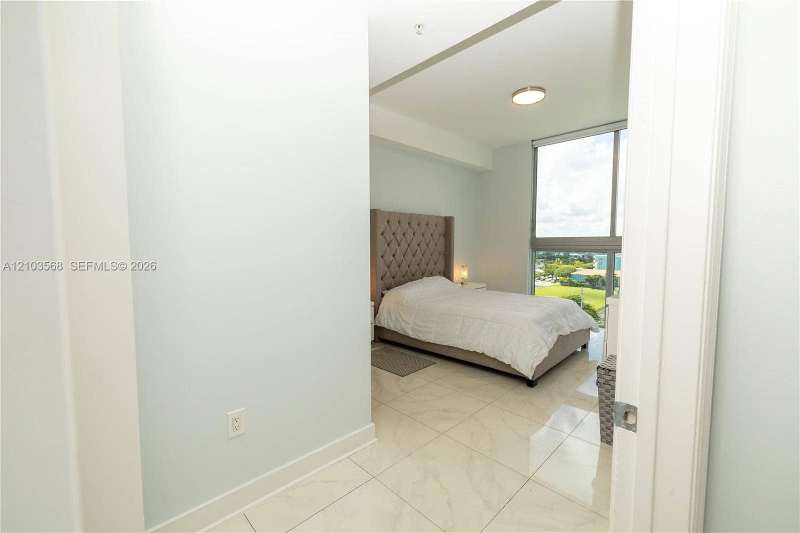 7901 Hispanola Avenue, #801, North Bay Village, FL 33141 Room featuring stone-finish tile flooring, floor-to-ceiling windows, and a flush-mount ceiling light fixture