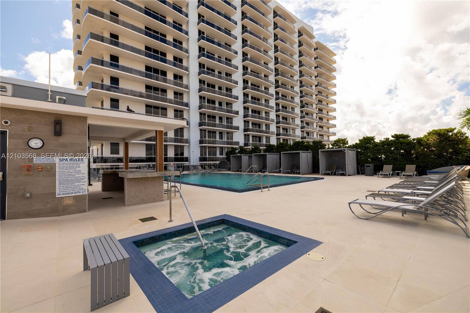 7901 Hispanola Avenue, #801, North Bay Village, FL 33141 Outdoor recreational area featuring a swimming pool, integrated spa, covered bar with stone-finished counters, and paved sun deck