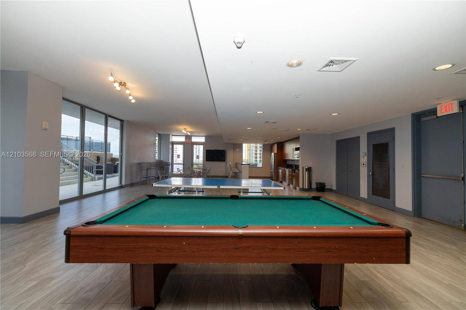 7901 Hispanola Avenue, #801, North Bay Village, FL 33141 Spacious recreation area featuring wood-finish flooring, recessed lighting, floor-to-ceiling windows, and a built-in kitchenette