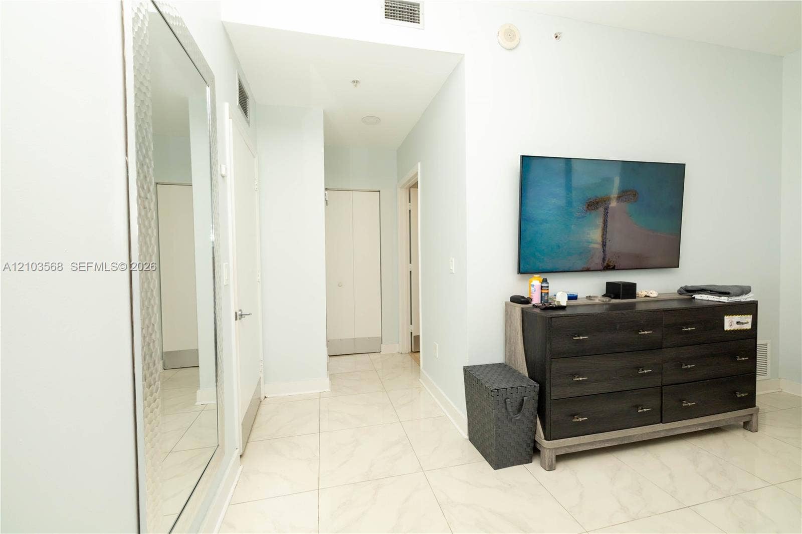 7901 Hispanola Avenue, #801, North Bay Village, FL 33141 Large-format floor tile, full-length wall mirror with textured frame, and white solid-core doors