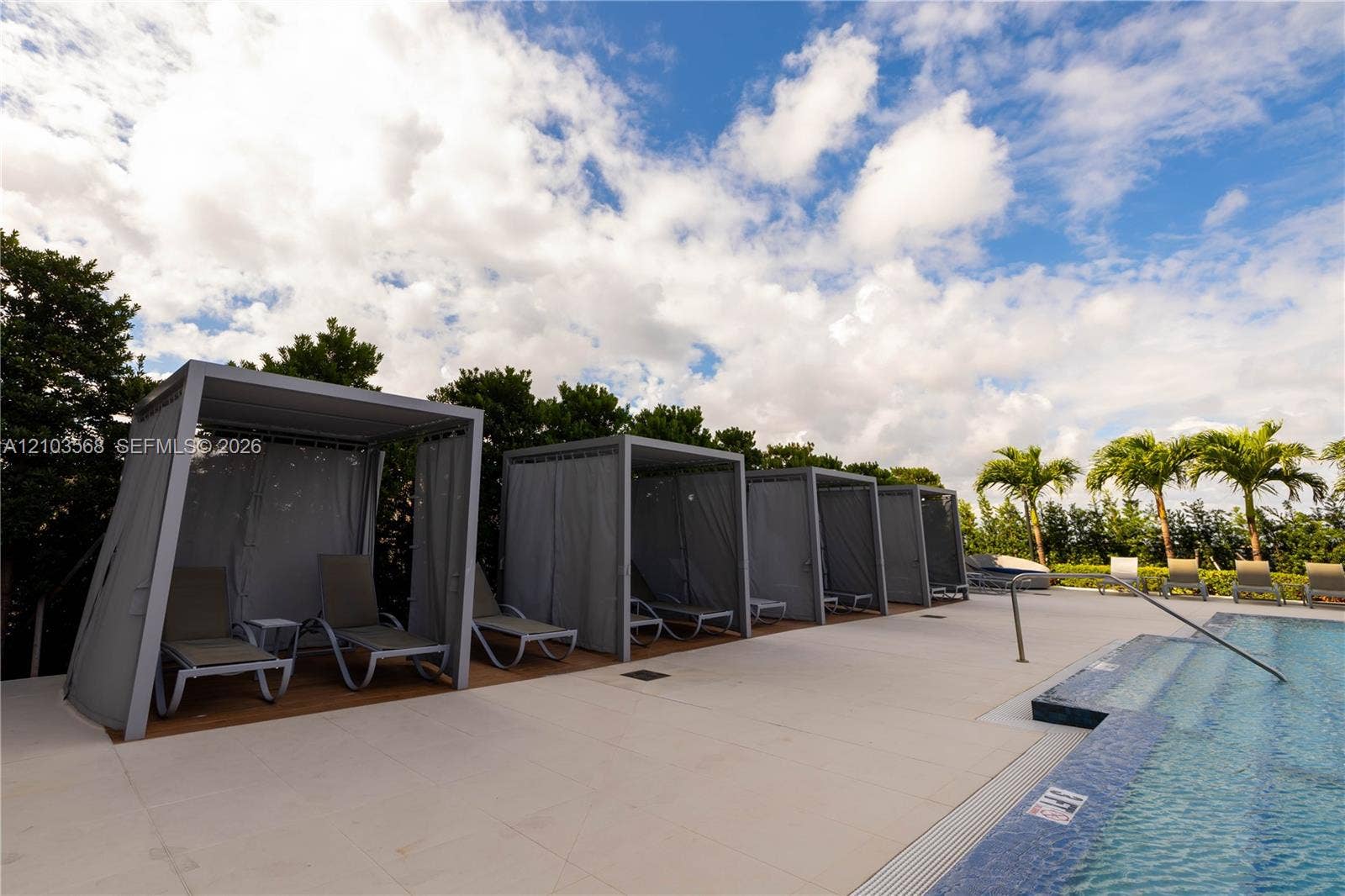 7901 Hispanola Avenue, #801, North Bay Village, FL 33141 Swimming pool with tiled waterline, concrete pool deck, and integrated shaded cabanas
