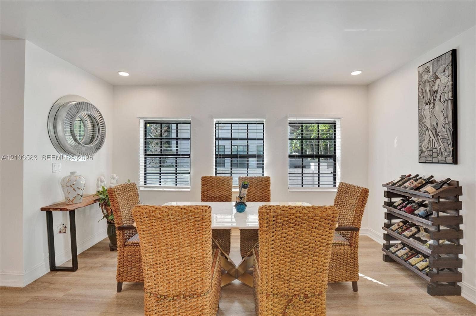 Dining area featuring wood-finish flooring, recessed lighting, and three grid-pane windows with integrated blinds