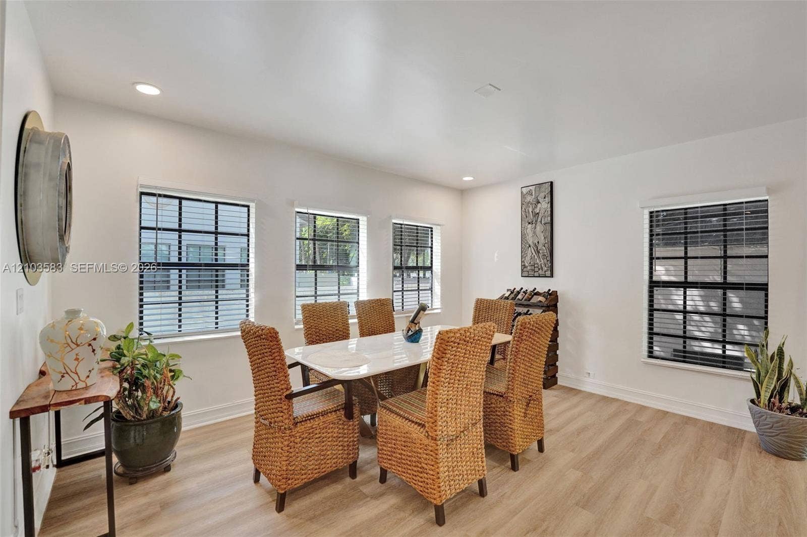 Dining area featuring wood-finish flooring, recessed lighting, and multiple windows with black muntin detailing