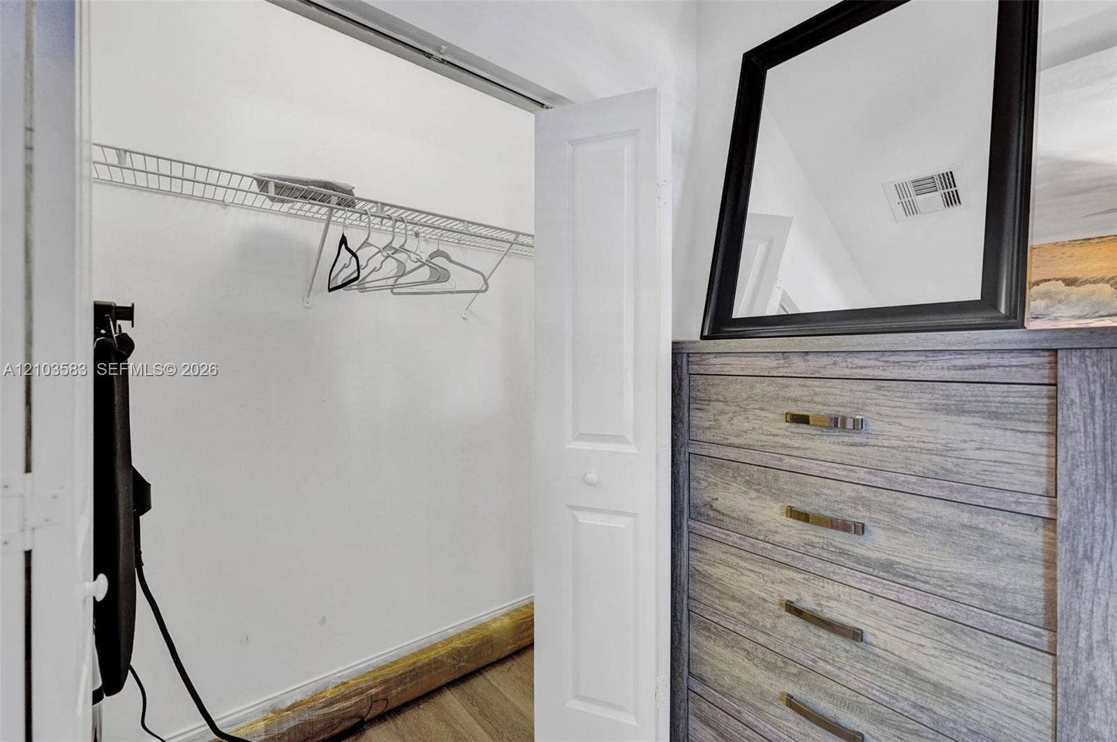 Reach-in closet featuring white bi-fold doors and integrated wire shelving