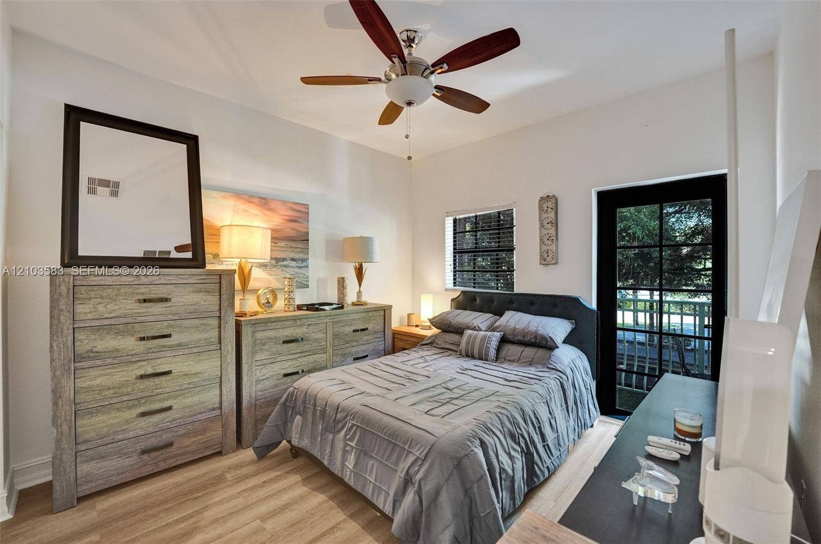 Wood-finish flooring, ceiling fan with integrated lighting, and glass-paneled exterior door