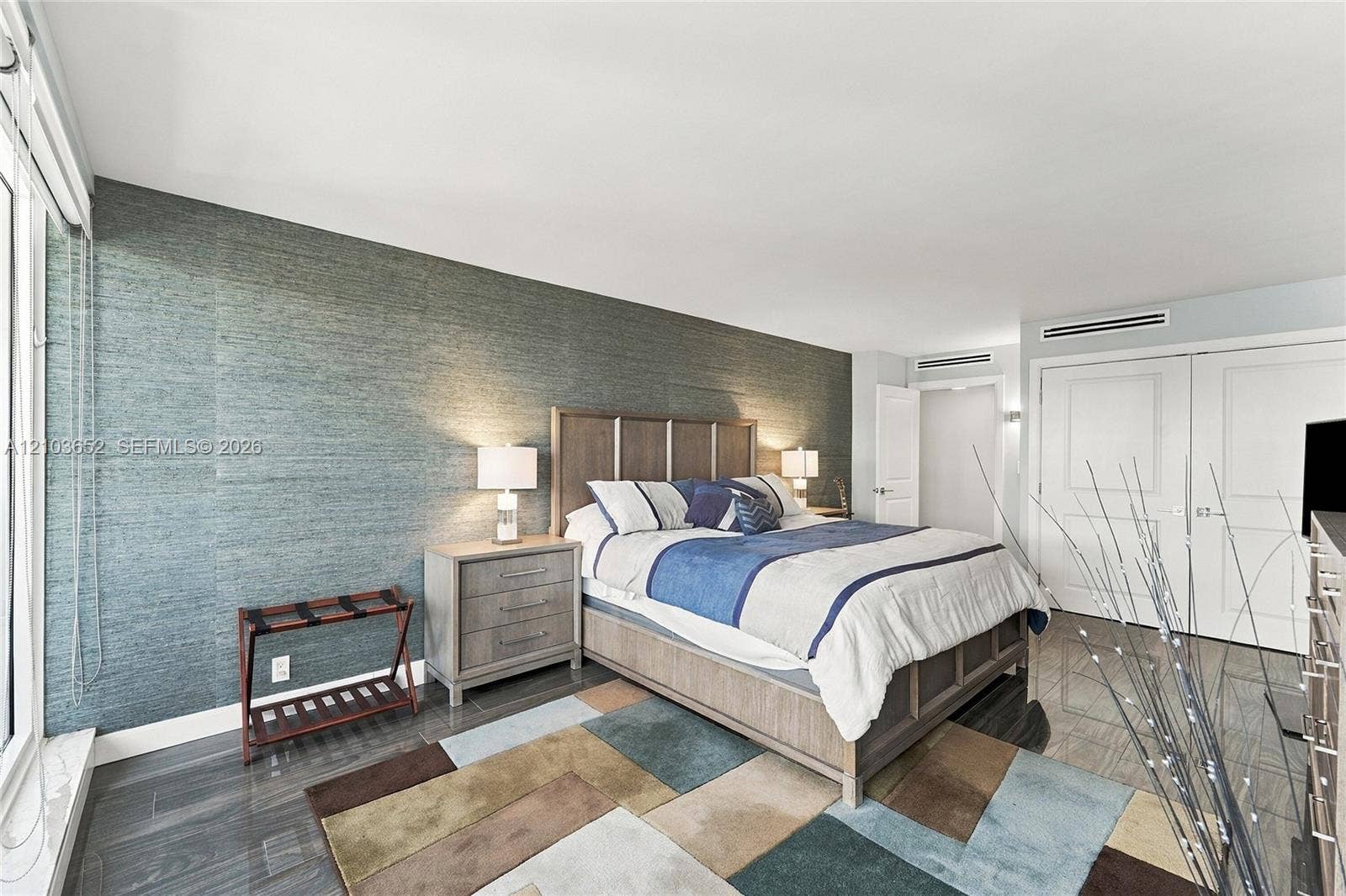 Textured accent wall, large-format polished flooring, and dual-panel interior doors