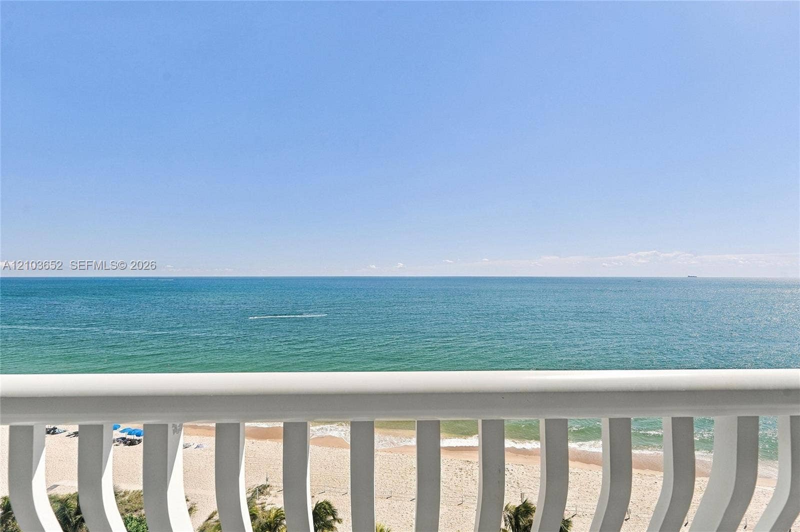 Private balcony featuring white vertical balusters and an oceanfront horizon