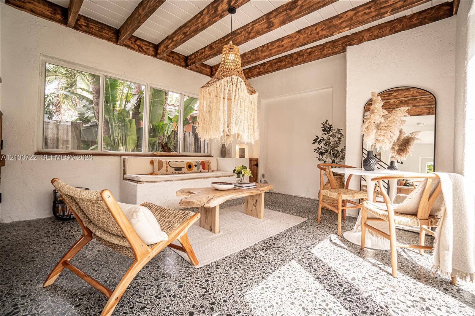 Exposed wood ceiling beams, terrazzo flooring, built-in masonry bench seating, and oversized multi-pane windows
