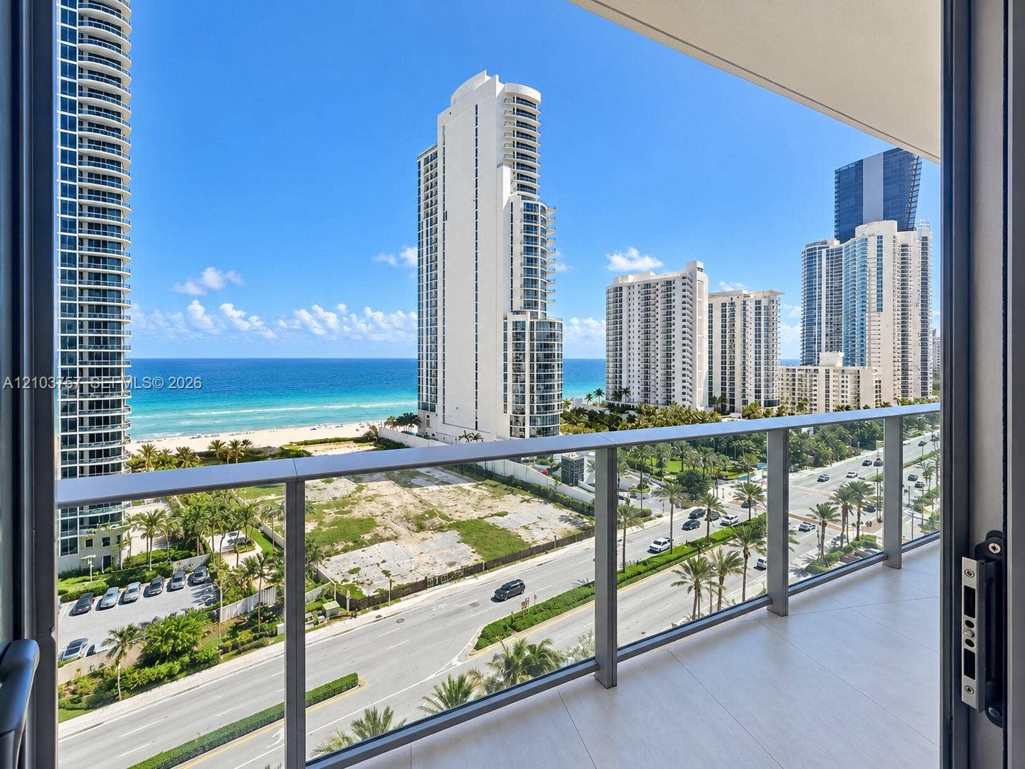 17550 Collins Avenue, #1103, Sunny Isles Beach, Sunny Isles Beach, FL 33160 Balcony with glass panel railings, wood-finish flooring, and coastal scenery