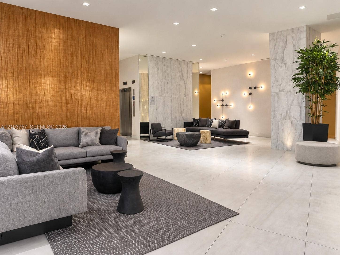 17550 Collins Avenue, #1103, Sunny Isles Beach, Sunny Isles Beach, FL 33160 Spacious common area featuring textured accent wall, light stone tile flooring, and modern wall sconces