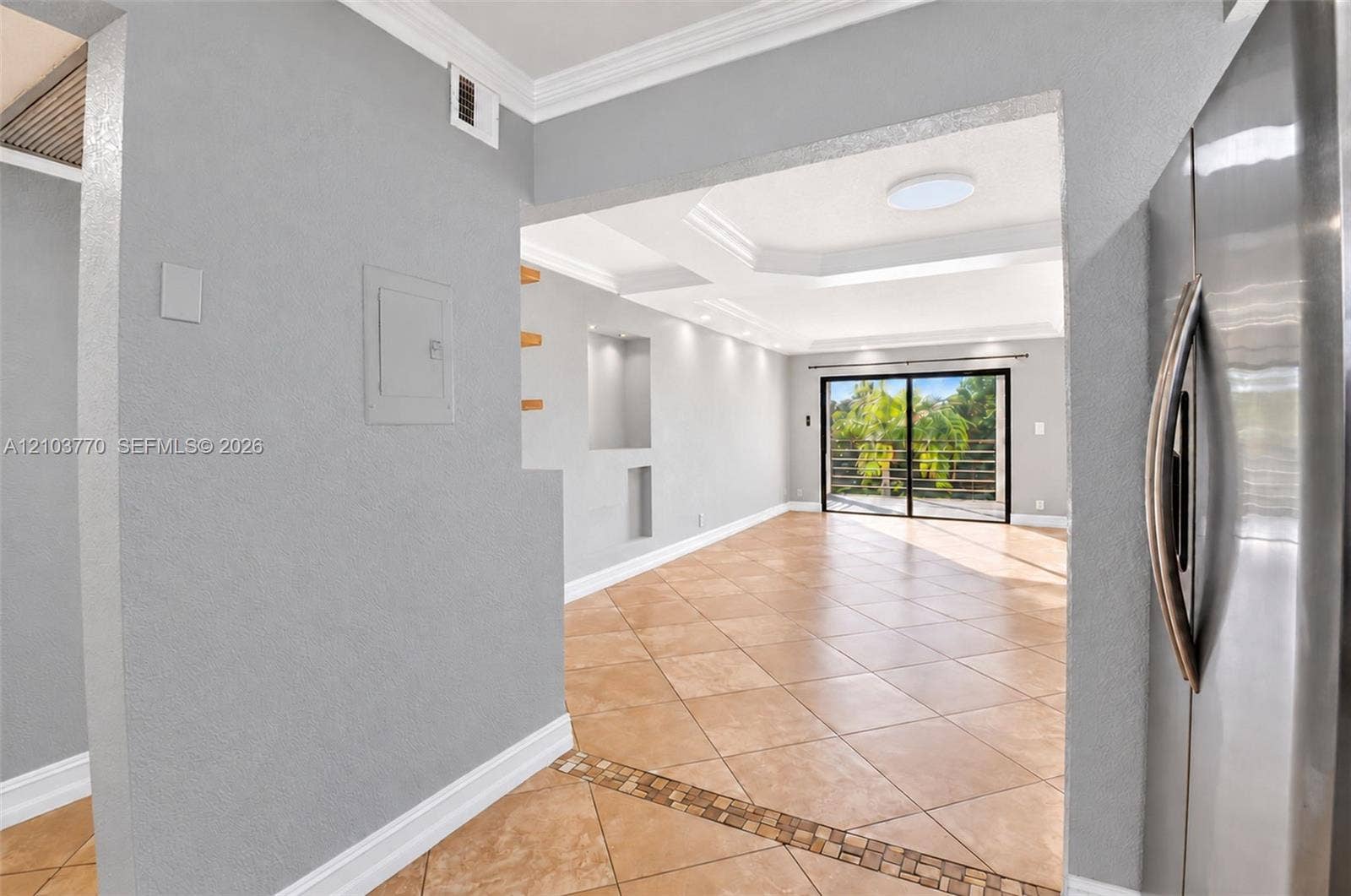 9440 SW 8th Street, #309, Boca Raton, Boca Raton, FL 33428 Porcelain tile flooring, recessed wall shelving, tray ceiling with recessed lighting, crown molding, and sliding glass doors
