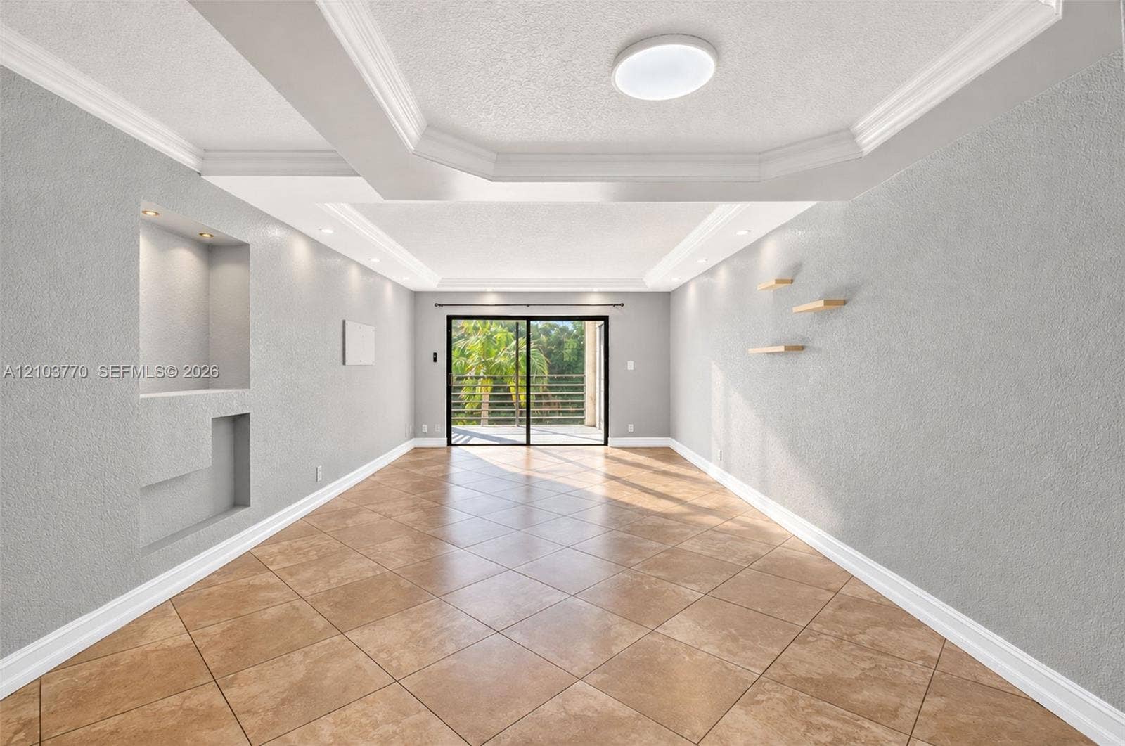 9440 SW 8th Street, #309, Boca Raton, Boca Raton, FL 33428 Recessed ceiling with crown molding, tile flooring, built-in wall niche with lighting, and sliding glass door to exterior
