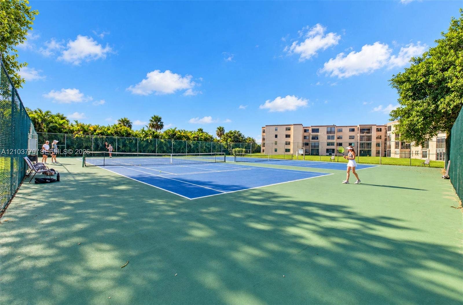 9440 SW 8th Street, #309, Boca Raton, Boca Raton, FL 33428 Two hard-surface tennis courts with blue and green playing areas, surrounded by chain-link fencing