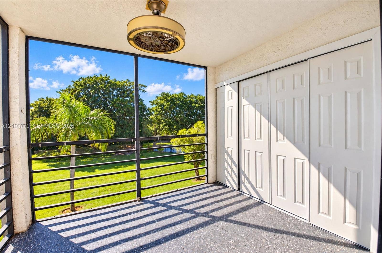 9440 SW 8th Street, #309, Boca Raton, Boca Raton, FL 33428 Screened balcony with textured flooring, a built-in ceiling fan, and sliding panel doors