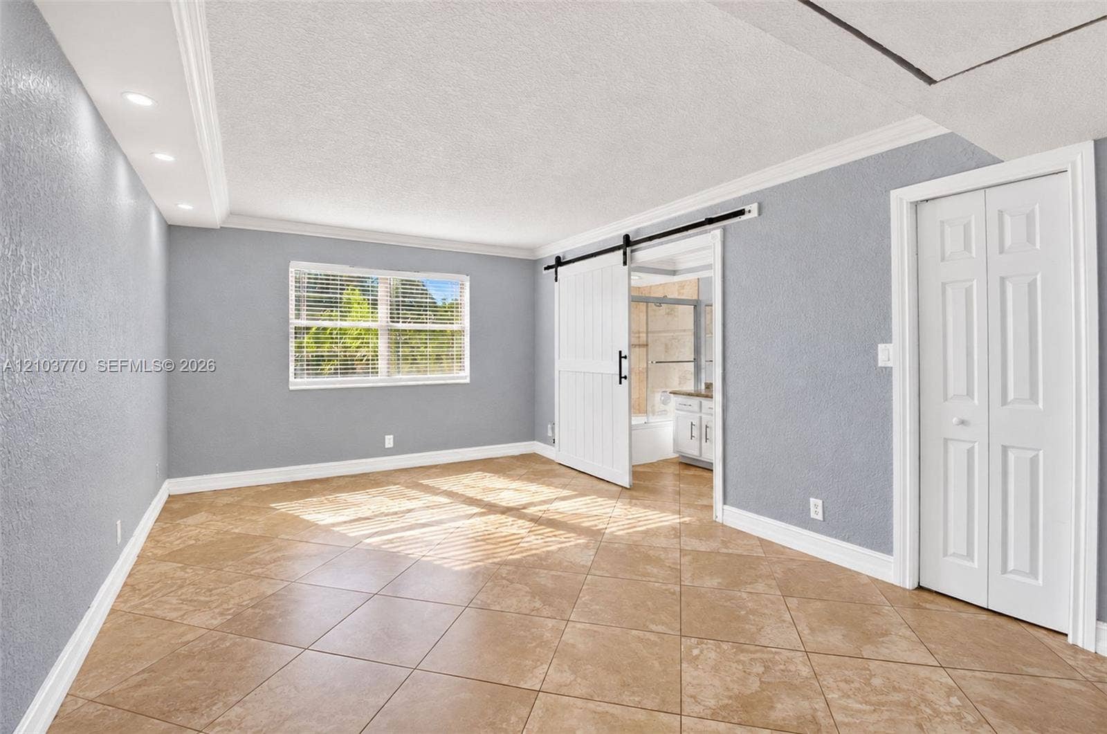 9440 SW 8th Street, #309, Boca Raton, Boca Raton, FL 33428 Tiled flooring, window with blinds, recessed lighting, white barn door, and bi-fold closet doors