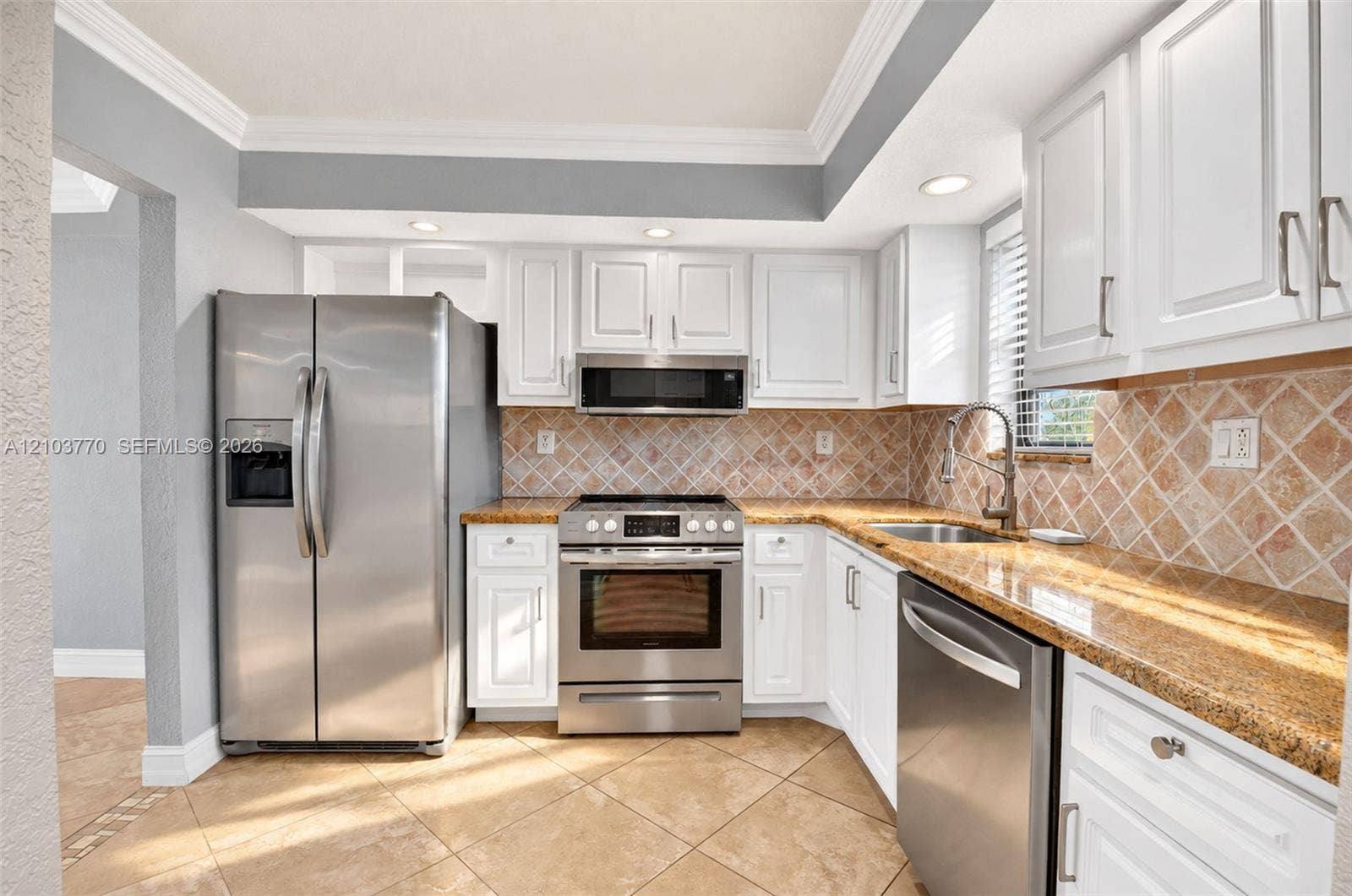 9440 SW 8th Street, #309, Boca Raton, Boca Raton, FL 33428 Kitchen featuring white cabinetry, stainless steel appliances, granite countertops, and a tiled backsplash