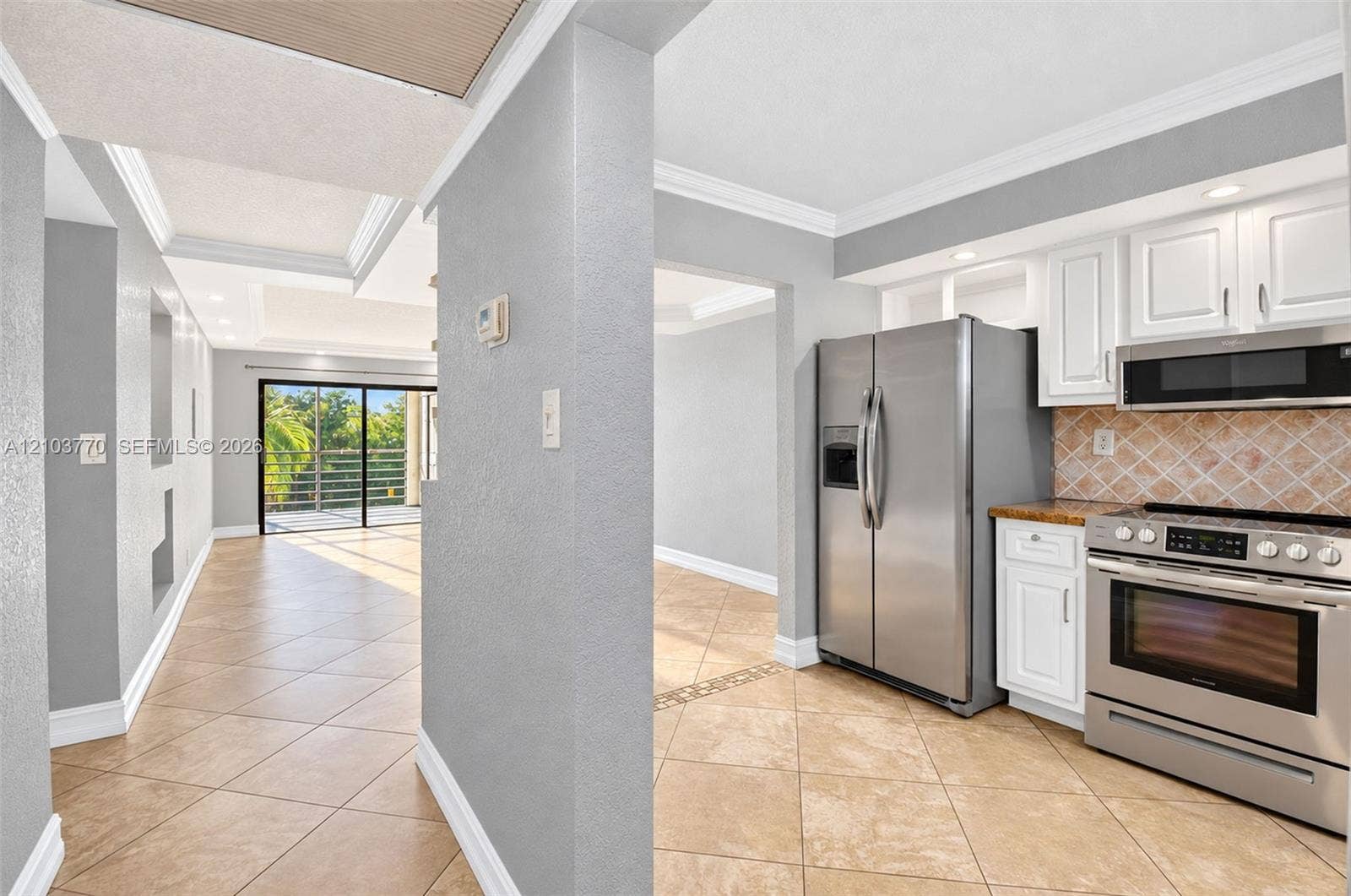 9440 SW 8th Street, #309, Boca Raton, Boca Raton, FL 33428 Gourmet kitchen with stainless steel appliances, white cabinetry, and a tile backsplash