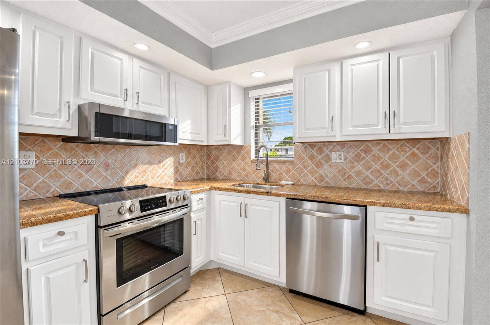 9440 SW 8th Street, #309, Boca Raton, Boca Raton, FL 33428 Updated kitchen featuring white shaker-style cabinetry, stainless steel appliances, granite countertops, and a full tile backsplash