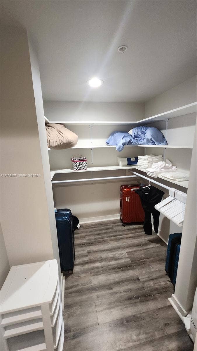300 S Biscayne Boulevard, #L-808, Miami, FL 33131 Walk-in closet featuring wood-finish flooring, white multi-tier shelving, and integrated hanging rods