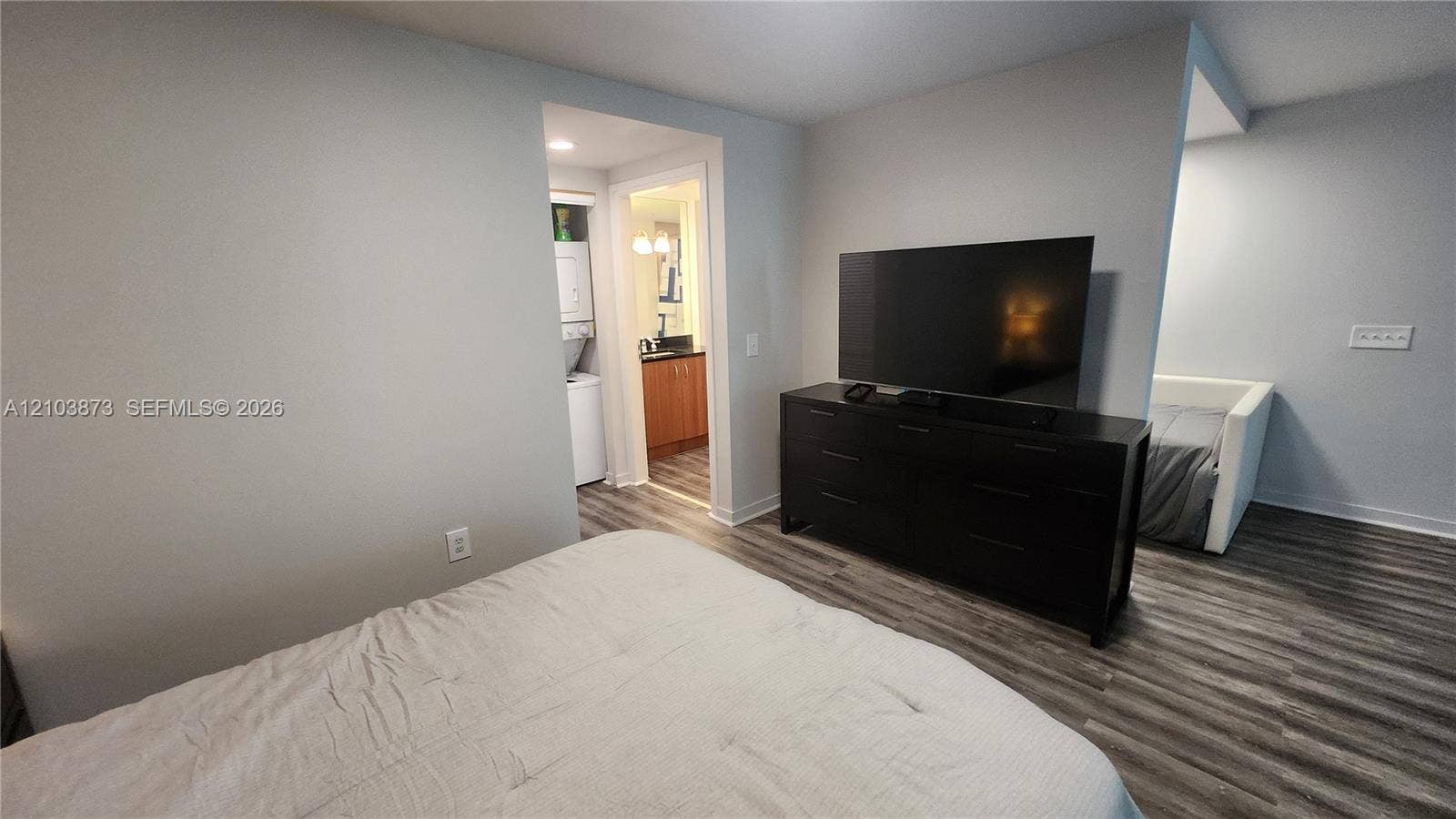 300 S Biscayne Boulevard, #L-808, Miami, FL 33131 Wood-finish flooring throughout, recessed ceiling lighting, and a utility area featuring a stacked laundry unit and cabinetry